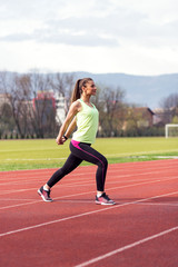 Fototapeta premium Sporty woman doing exercise at stadium