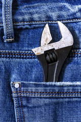Adjustable wrench in the back pocket of denim jeans