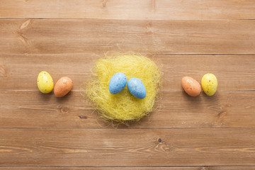 Happy easter eggs on color for holiday on wooden background top view flat lay
