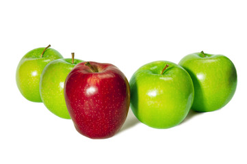 Horizontal shot of a red delicious apple standing in front of four green granny smith apples on a white background.