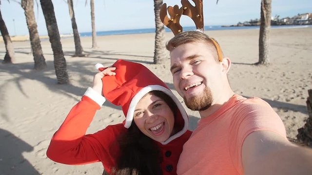 Happy Christmas couple selfie picture on beach vacation