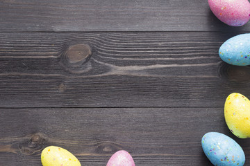 Happy easter eggs on color for holiday on wooden background top view flat lay with copy space