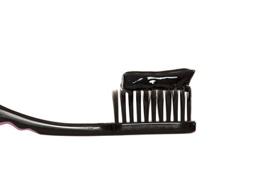 Black tooth paste with active charcoal, and black tooth brush on white background