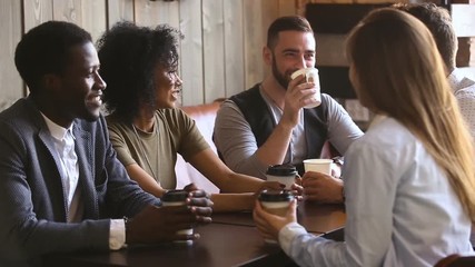 Diverse young guys spending time together in cafe, multinational close best friends talking and laughing at meeting in cafeteria, positive mates enjoying hanging out together relaxing in coffee house - Powered by Adobe