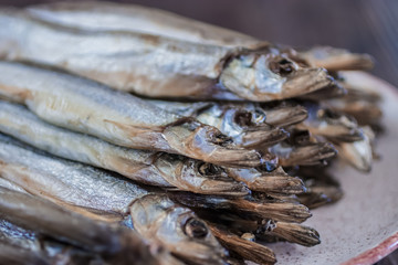 Capelin smoked on brown wooden table.