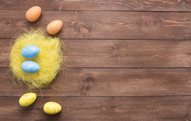 Happy easter eggs on color for holiday on wooden background top view flat lay with copy space
