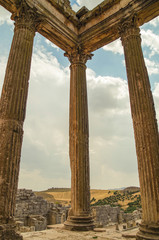 Fototapeta premium Columns and entablature of the Corinthian order. Roman ruins and uninhibited view of the surrounding plains. The capitol is a Roman temple. Dougga or Thugga - UNESCO World Heritage site. Tunisia
