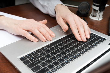 Closeup of a female hands busy typing on laptop. Copy space.