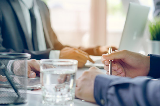 entrepreneurship new business start up meeting. Close up hand of young asian businessman taking note to notebook in the conference meeting for giving advice to new entrepreneurs