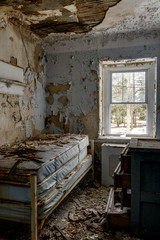 Fototapeta na wymiar Derelict Bedroom with Bed & Dresser - Abandoned Sleighton Farm School - Pennsylvania