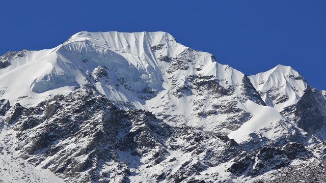 Mountain peak of Naya Kanga covered by thil glacier and snow. View from Kyanjin Gumba, Langtang National Park, Nepal.