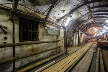 Naklejka na ściany i meble Underground coal ore mine shaft tunnel gallery with light