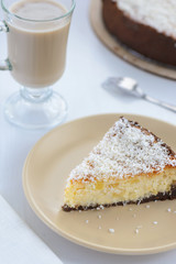 slice of a cheesecake with a cup of coffee on a white background