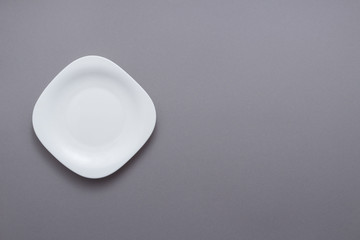 Single empty plate on grey background top view flat lay copy space