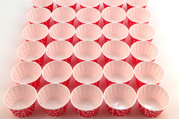 Forms of red paper for homemade baking, set in even rows.