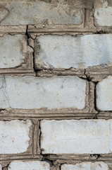 Old white brick wall with cracks. Close-up.