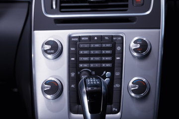 Interior of a modern car where you can see the gear lever and the console