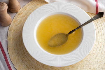 Bone broth made from chicken in a soup plate