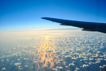 Obraz premium Airplane wing and view of clouds below