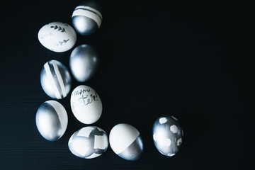 Group of diverse silver Easter eggs on black background, original stylish idea, selective focus