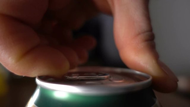 Close up of hand opening a beer can, slow motion