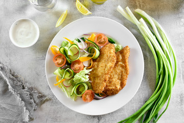 Vegetable salad from tomato, zucchini, radish, greens and schnitzel