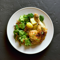 Baked chicken leg with potato and green salad