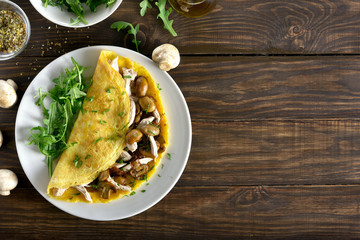  Omelette stuffed with mushrooms, pieces of chicken meat, greens