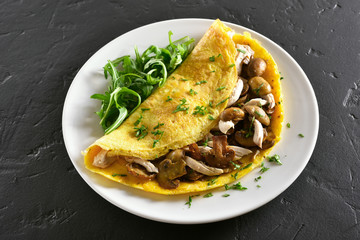 Omelette stuffed with mushrooms, chicken meat, greens