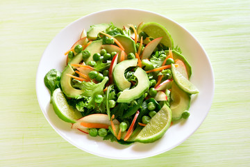 Vegetable fruit salad with avocado, green pea, greens, apple