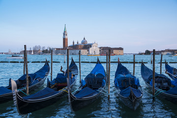 Fototapeta na wymiar Venice, Italy: gondolas moored in the San Marco basin and the San Giorgio Maggiore church. Italian landscape.
