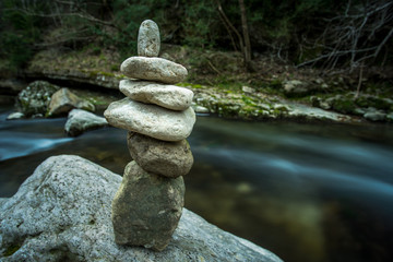 six pierres empilées sur un rocher au bord d'une rivière