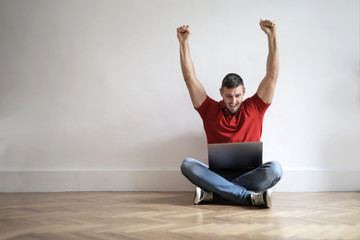 Obraz premium Jubilant man using a laptop