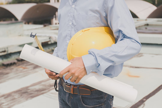 Engineers agree to work together,Architecture at construction site,Consultation for workers,engineer holding white helmet and drawing,Concept foreman,technician man holding safety hat - Powered by Adobe