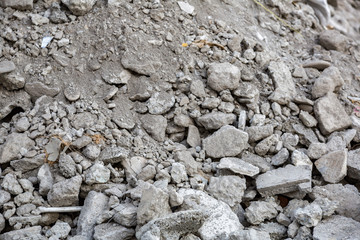 A pile of broken gray bricks on the street construction site
