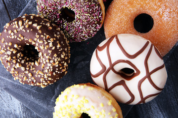 assorted donuts with chocolate frosted, pink glazed and sprinkles donuts.
