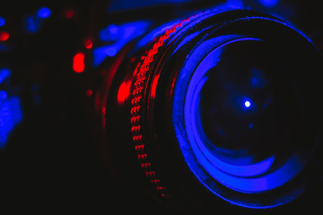 Fototapeta na wymiar Professional camera and lens illuminated in red and blue