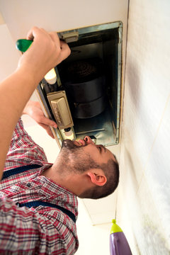 Repairman work on ventilation in the kitchen