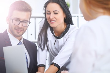 Business people at a meeting in the office. Focus on woman pointing into laptop