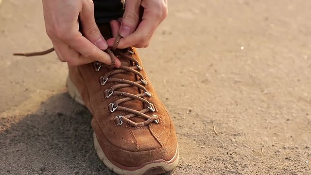 Man tying shoelaces on shoes or sneakers, close-up