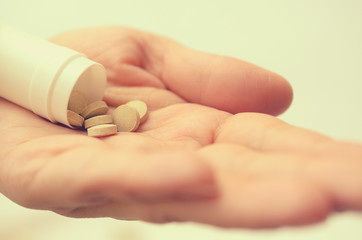Tablets with a package in the palm of a close-up.