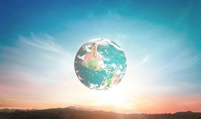 Naklejka premium Earth globe in clear blue and sunset sky over scenic landscape