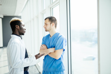 Mixed race Two doctors discussing results of the analysis in modern hospital