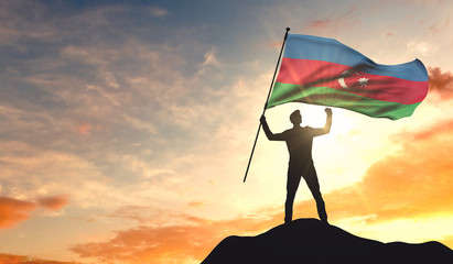 Azerbaijan flag being waved by a man celebrating success at the top of a mountain. 3D Rendering