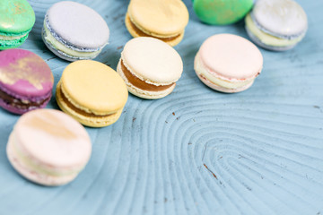 Close-up colorful French or Italian macaron on blue wooden table. Macarons is French dessert served with tea or coffee. wallpaper, Horizontal photo
