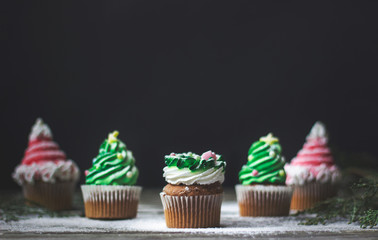 Decorated christmas cupcakes, on wooden background with copy space
