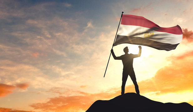 Egypt flag being waved by a man celebrating success at the top of a mountain. 3D Rendering
