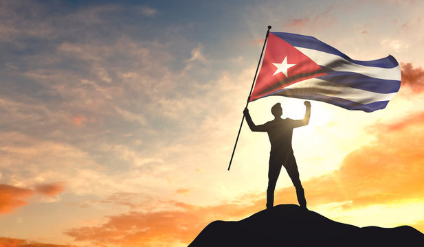 Cuba flag being waved by a man celebrating success at the top of a mountain. 3D Rendering