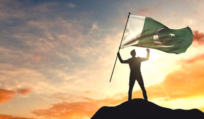 Pakistan flag being waved by a man celebrating success at the top of a mountain. 3D Rendering