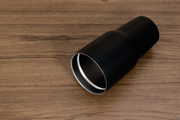 Black colour stainless steel tumbler or cold storage cup with water straw and cap on wood background.